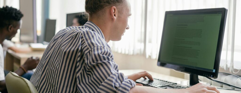 Focused student working on a computer in a bright, modern study space.